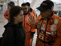 Hector Mendez, better known as El Chino, head and founder of the Azteca Topos International Rescue Brigade, talks with a Turkish citizen ins...