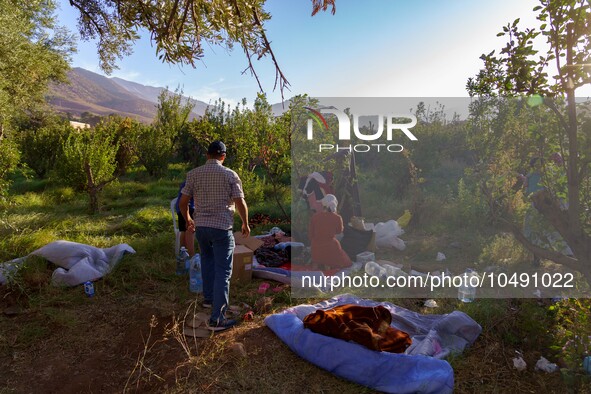 A family whose house was destroyed by the earthquake in the village of Ijoukak is setting up a makeshift bed where they will spend at least...