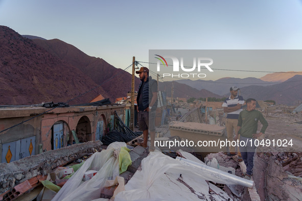 Three men in the village of Ijoukak, which was completely destroyed by the earthquake, are observing the rubble of their village. 