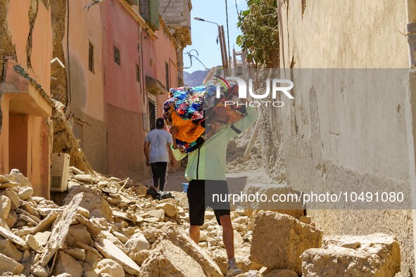 A young man in the village of Amizmiz is retrieving blankets from his home amid the rubble. 