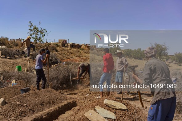 A group of men is digging graves for the earthquake victims in the village of Tafeghaghte. 