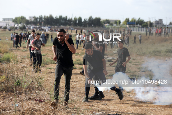 A Palestinian protester holds a tear gas canister fired by Israeli forces during a demonstration along the border between the Gaza Strip and...