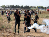 A Palestinian protester holds a tear gas canister fired by Israeli forces during a demonstration along the border between the Gaza Strip and...