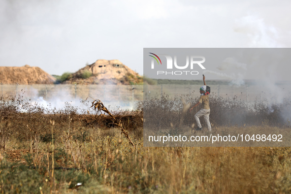 A Palestinian protester holds a tear gas canister fired by Israeli forces during a demonstration along the border between the Gaza Strip and...