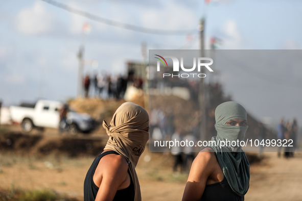 Palestinian protesters flee from tear gas during clashes with Israeli forces in a demonstration along the border between the Gaza Strip and...