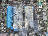 An aerial view shows smoke rises after a massive fire broke out, at the Mohammadpur Krishi Market in Dhaka, Bangladesh, on September 14, 202...