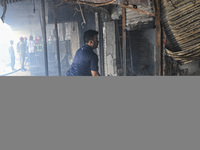 A shop owner tries to extinguish a fire that broke out, at the Mohammadpur Krishi Market in Dhaka, Bangladesh, on September 14, 2023.
 (