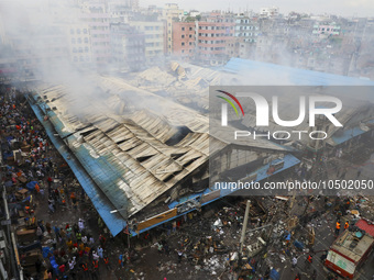 
Firefighters and volunteers are seen at the Mohammadpur Krishi Market, while smoke rises after a massive fire broke out, in Dhaka, Banglad...