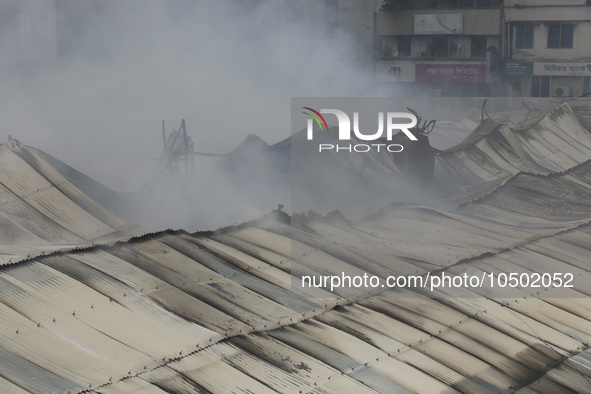 
Firefighters and volunteers are seen at the Mohammadpur Krishi Market, while smoke rises after a massive fire broke out, in Dhaka, Banglad...