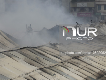 
Firefighters and volunteers are seen at the Mohammadpur Krishi Market, while smoke rises after a massive fire broke out, in Dhaka, Banglad...