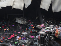 
Firefighters and volunteers are seen at the Mohammadpur Krishi Market, while smoke rises after a massive fire broke out, in Dhaka, Banglad...