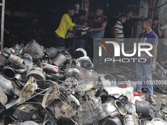 
Firefighters and volunteers are seen at the Mohammadpur Krishi Market, while smoke rises after a massive fire broke out, in Dhaka, Banglad...