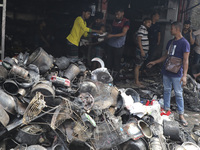 
Firefighters and volunteers are seen at the Mohammadpur Krishi Market, while smoke rises after a massive fire broke out, in Dhaka, Banglad...