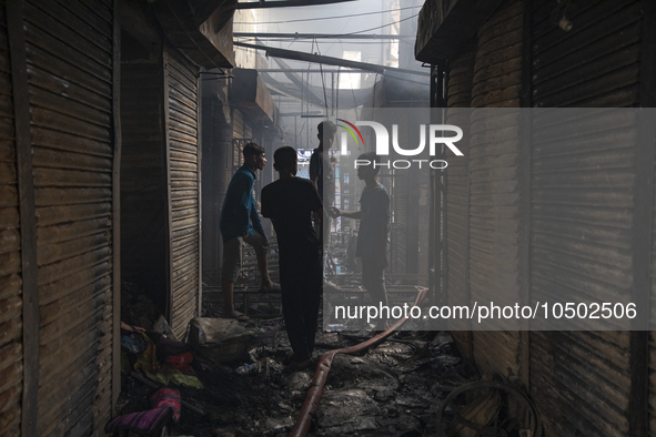 Shopkeepers look for the goods that survived from the massive fire at Mohammadpur Krishi Market in Dhaka on September 14, 2023. A massive bl...