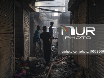 Shopkeepers look for the goods that survived from the massive fire at Mohammadpur Krishi Market in Dhaka on September 14, 2023. A massive bl...