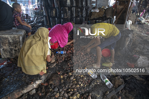 Shopkeepers look for the goods that survived from the massive fire at Mohammadpur Krishi Market in Dhaka on September 14, 2023. A massive bl...