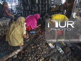 Shopkeepers look for the goods that survived from the massive fire at Mohammadpur Krishi Market in Dhaka on September 14, 2023. A massive bl...