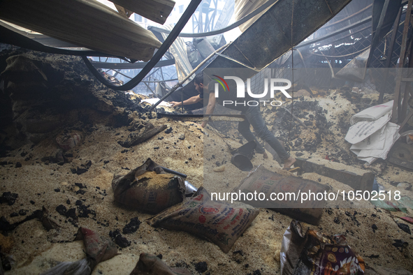 Shopkeepers look for the goods that survived from the massive fire at Mohammadpur Krishi Market in Dhaka on September 14, 2023. A massive bl...