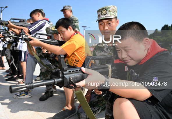 Children experience militia weapons and equipment at a new recruit training camp in Tianjia town, Neijiang city, Sichuan province, China, Se...