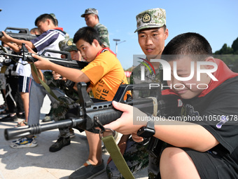 Children experience militia weapons and equipment at a new recruit training camp in Tianjia town, Neijiang city, Sichuan province, China, Se...