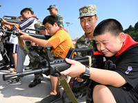 Children experience militia weapons and equipment at a new recruit training camp in Tianjia town, Neijiang city, Sichuan province, China, Se...