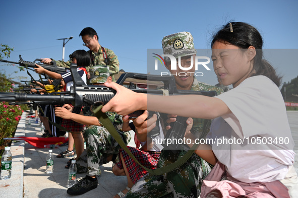 Children experience militia weapons and equipment at a new recruit training camp in Tianjia town, Neijiang city, Sichuan province, China, Se...