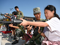 Children experience militia weapons and equipment at a new recruit training camp in Tianjia town, Neijiang city, Sichuan province, China, Se...