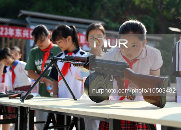 Children inspect militia weapons and equipment at a new recruit training camp in Tianjia town, Neijiang city, Sichuan province, China, Septe...