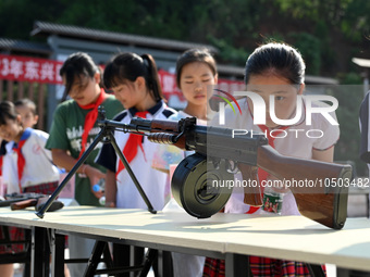 Children inspect militia weapons and equipment at a new recruit training camp in Tianjia town, Neijiang city, Sichuan province, China, Septe...