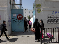 Children enter a school building as the 2023-2024 academic year begins for Tunisian students after the summer holiday in Tunis, Tunisia on S...