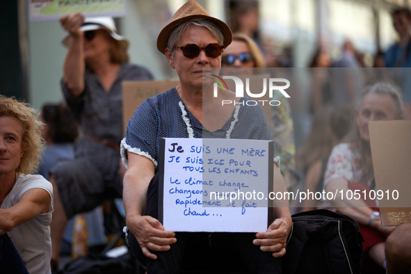 A woman holds a placard reading 'I'm a mother, I'm there for all children. The Climate chnage, let's us change...Rapidly..It's hot'. Extinct...