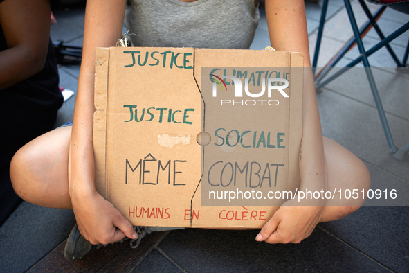 A young woman holds a placard reading 'Climatic justice, Social justice, same fight. Angry human beings'. Extinction Rebellion (XR) Toulouse...