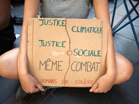 A young woman holds a placard reading 'Climatic justice, Social justice, same fight. Angry human beings'. Extinction Rebellion (XR) Toulouse...