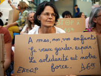 A woman holds a crdaboard reading 'For my, yours, ours children, I want to keep hope. Solidarity is our strenght'. A woman holds a cardboard...