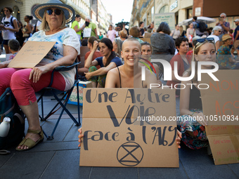 A young woman holds a placard reading 'Another way against the A69'. Extinction Rebellion (XR) Toulouse organized a sit-in of women in one o...