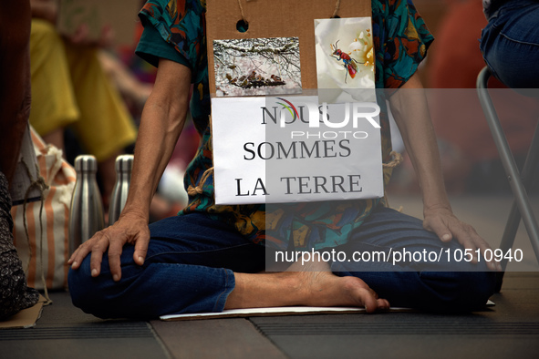 A woman holds a placard reading 'We're Earth'. Extinction Rebellion (XR) Toulouse organized a sit-in of women in one of the most frequented...