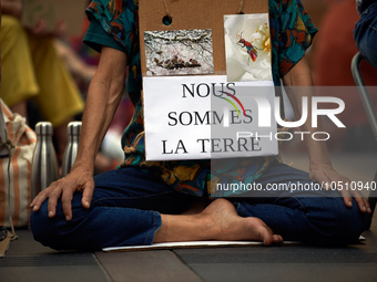 A woman holds a placard reading 'We're Earth'. Extinction Rebellion (XR) Toulouse organized a sit-in of women in one of the most frequented...