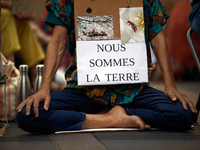 A woman holds a placard reading 'We're Earth'. Extinction Rebellion (XR) Toulouse organized a sit-in of women in one of the most frequented...