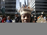 An indigenous person marches among thousands representing various groups participate in the ''End of Fossil Fuels'' protest across Midtown M...