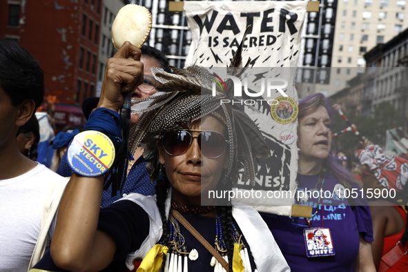 An indigenous person marches among thousands representing various groups participate in the ''End of Fossil Fuels'' protest across Midtown M...