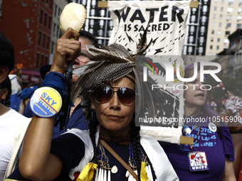 An indigenous person marches among thousands representing various groups participate in the ''End of Fossil Fuels'' protest across Midtown M...