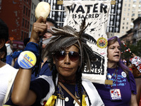 An indigenous person marches among thousands representing various groups participate in the ''End of Fossil Fuels'' protest across Midtown M...