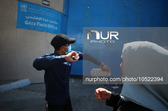 Palestinian protesters throw eggs at the entrance of the Gaza City headquarters of the United Nations Relief and Works Agency for Palestine...