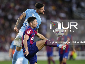 Robert Lewandowski centre-forward of Barcelona and Poland and Unai Nuñez centre-Back of Celta de Vigo and Spain compete for the ball during...