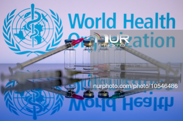 World Health Organization (WHO) displayed on screen with pharmacy medical syringe and vaccine vial. Seen in this photo illustration, in Brus...