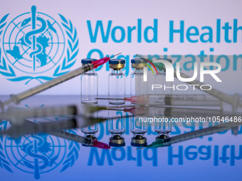 World Health Organization (WHO) displayed on screen with pharmacy medical syringe and vaccine vial. Seen in this photo illustration, in Brus...