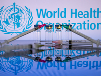 World Health Organization (WHO) displayed on screen with pharmacy medical syringe and vaccine vial. Seen in this photo illustration, in Brus...