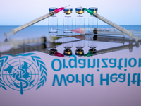 World Health Organization (WHO) displayed on screen with pharmacy medical syringe and vaccine vial. Seen in this photo illustration, in Brus...