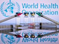 World Health Organization (WHO) displayed on screen with pharmacy medical syringe and vaccine vial. Seen in this photo illustration, in Brus...