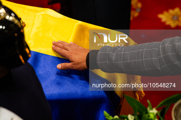 A men touches the coffin of the late Colombian artist Fernando Botero who lies inside the National Congress during his wake in Bogota, Colom...